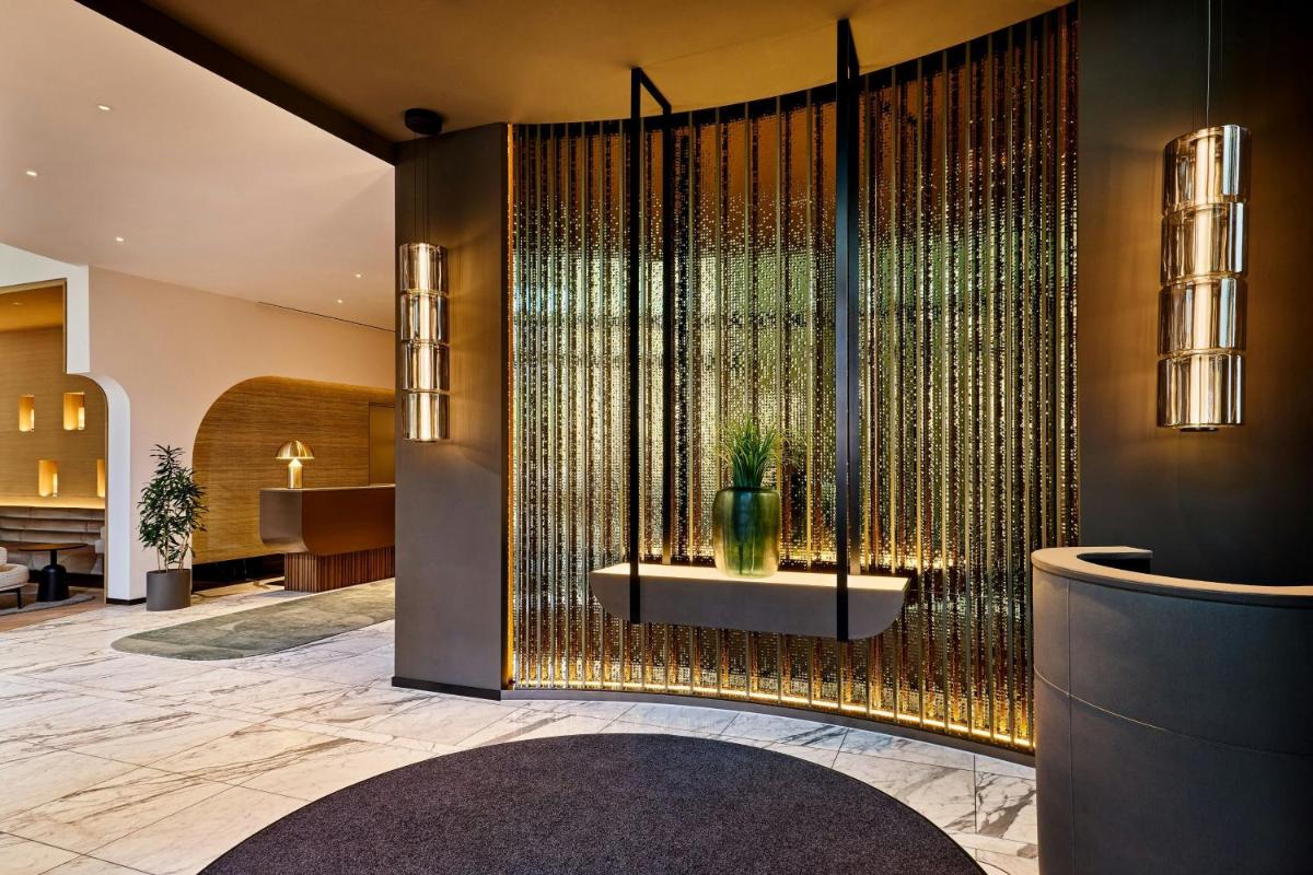 eine Lobby mit einer großen Wand mit einer Topfpflanze in der Unterkunft JW Marriott Hotel Frankfurt in Frankfurt am Main