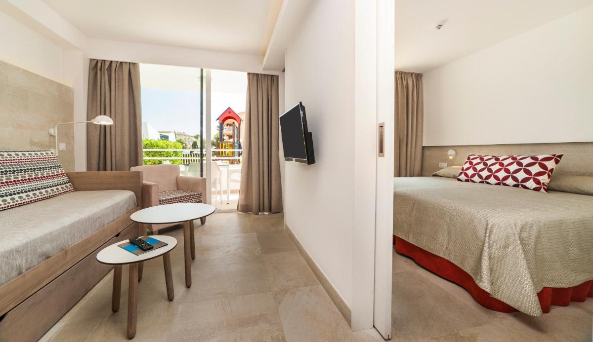 Una habitación de hotel con una cama, un sofá y un televisor. en Hoposa Hotel & Apartaments VillaConcha, en Puerto Pollensa 39 fotos más