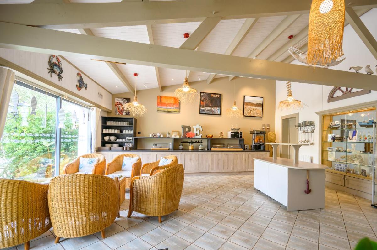 une cuisine avec des chaises et une table dans une pièce dans l'établissement Hôtel Le Peu Breton, à Sainte-Marie de Ré