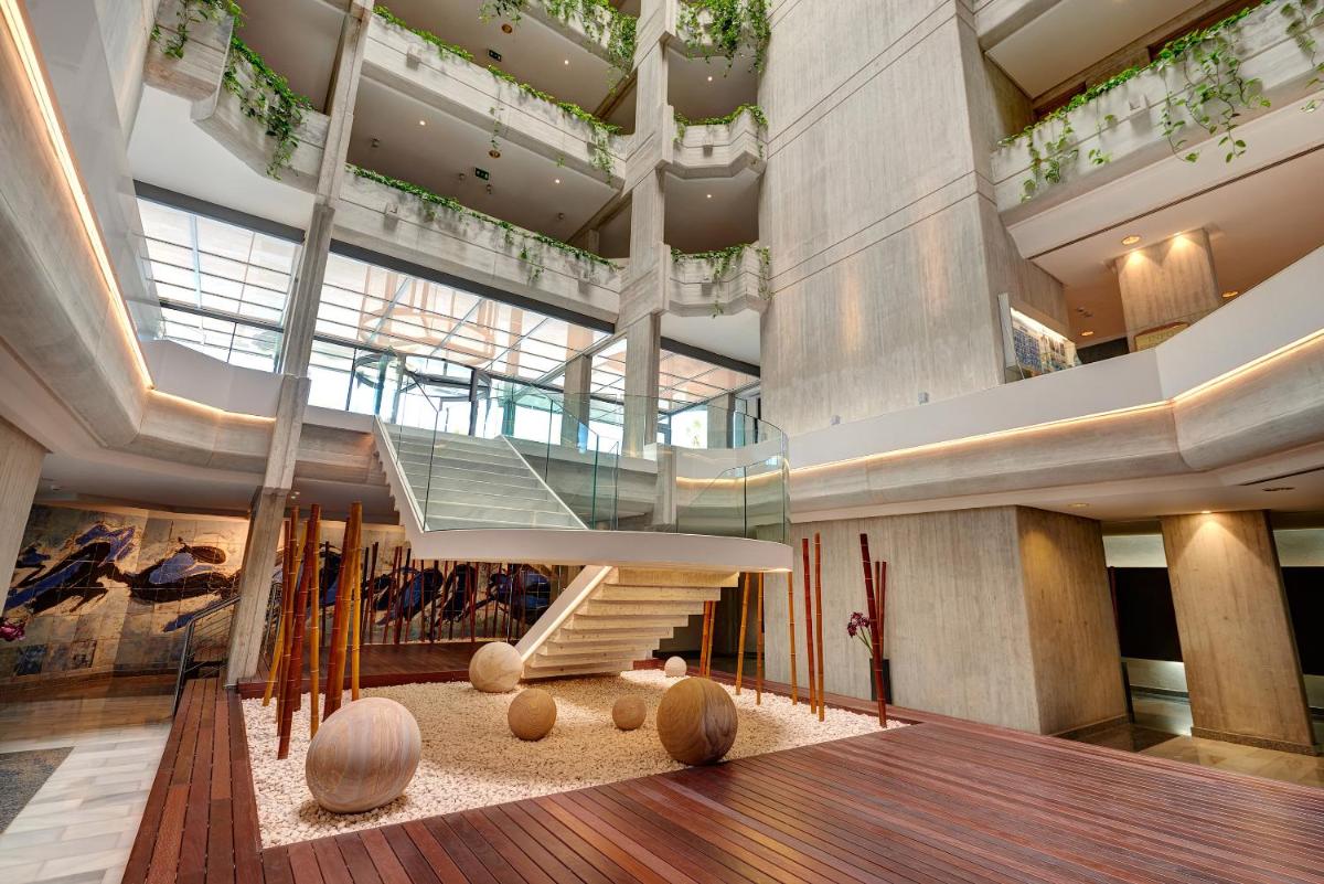 Un vestíbulo con escalera en un edificio. en Hipotels Mediterraneo Hotel - Adults Only, en Sa Coma