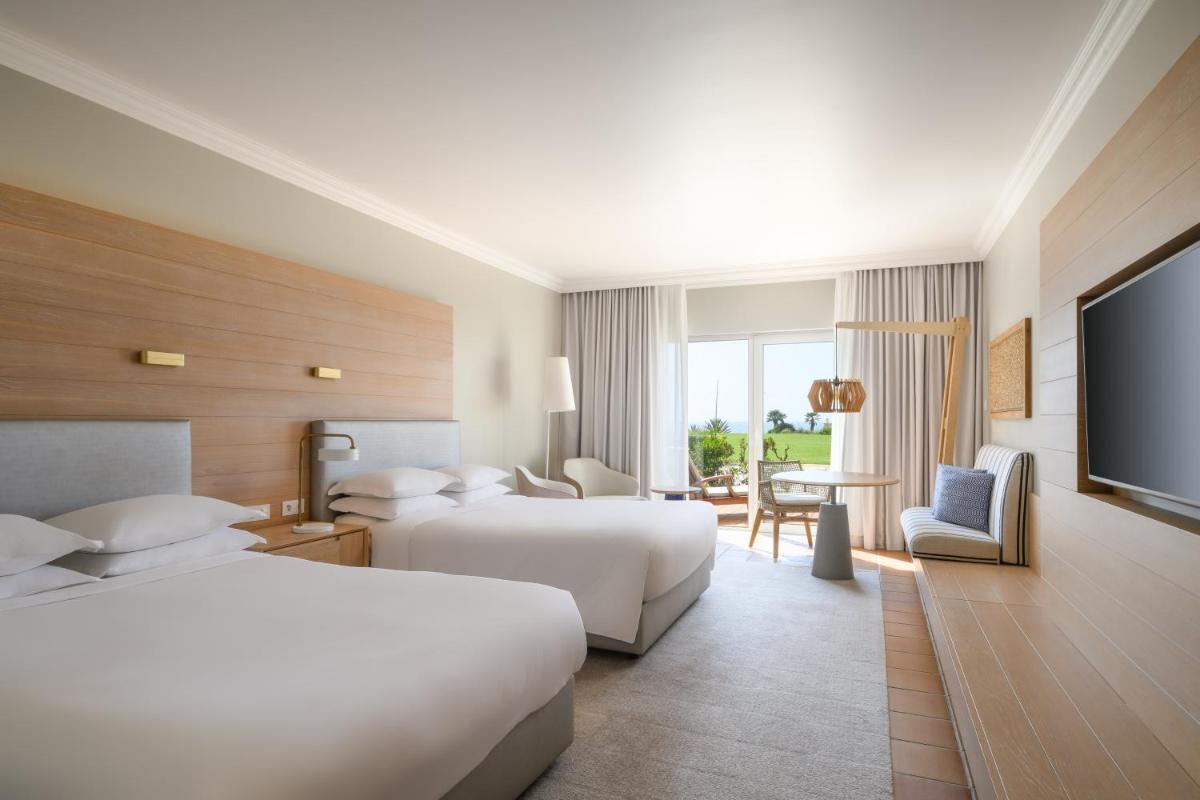 um quarto de hotel com duas camas e uma TV de tela plana em Praia D'El Rey Marriott Golf & Beach Resort em Praia del Rei