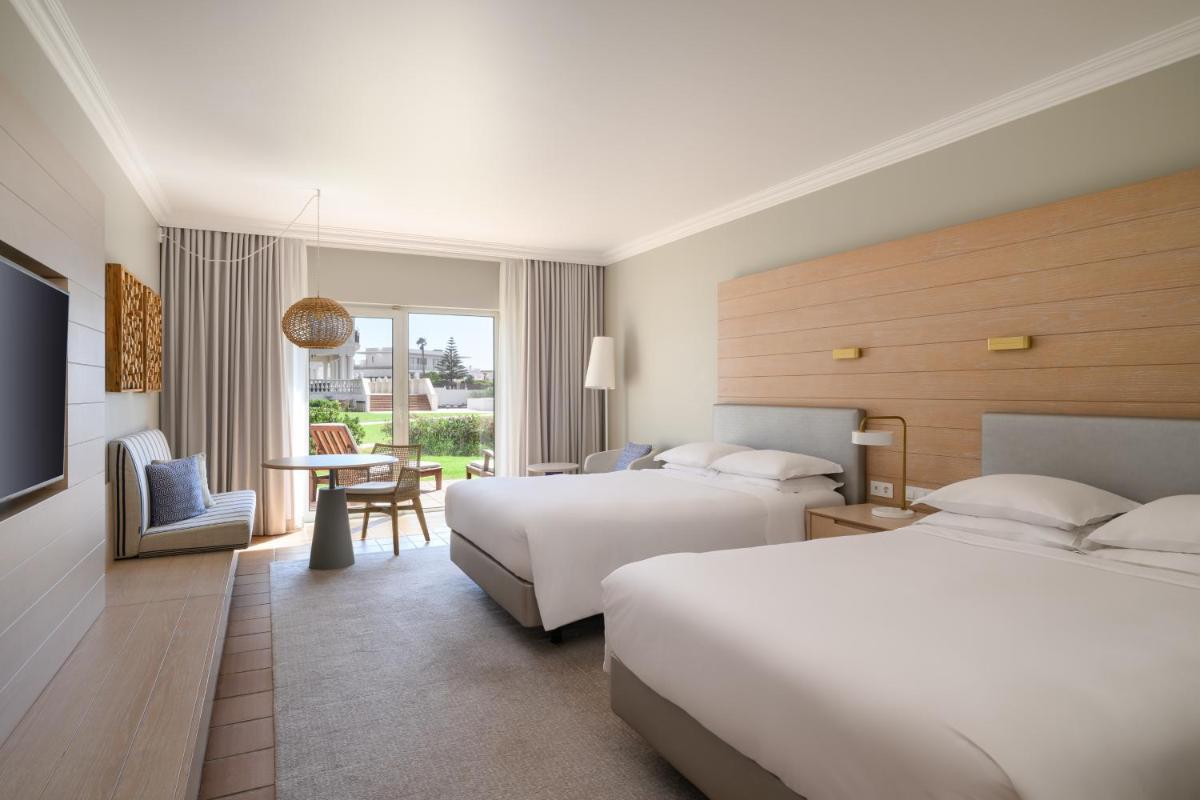 um quarto de hotel com duas camas e uma mesa em Praia D'El Rey Marriott Golf & Beach Resort em Praia del Rei