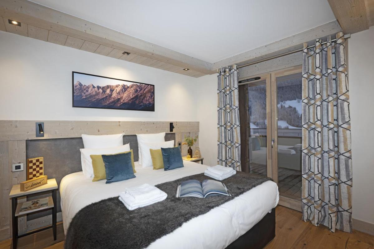 une chambre avec un grand lit et une fenêtre dans l'établissement MGM Hôtels & Résidences - Résidence Chalets de Joy, au Grand-Bornand