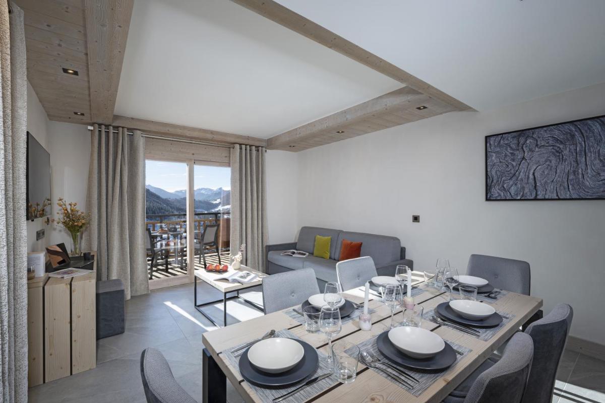 une salle à manger avec une table et des chaises et un salon dans l'établissement MGM Hôtels & Résidences - Résidence Chalets de Joy, au Grand-Bornand 50 autres photos