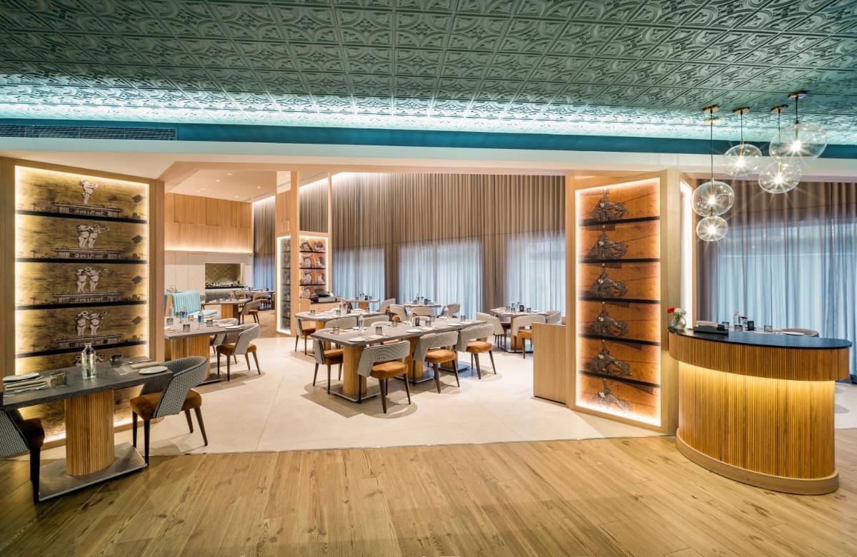 a restaurant with tables and chairs in a room at The Park Chennai in Chennai