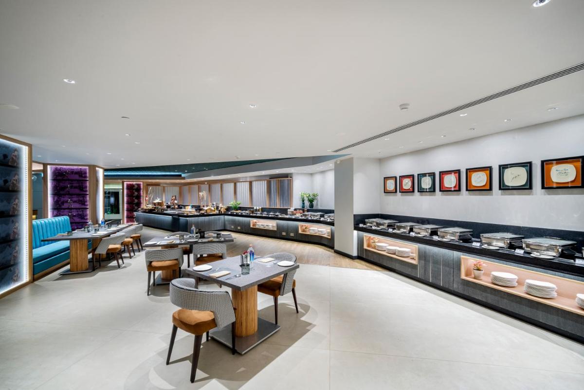 a restaurant with tables and chairs and counters at The Park Chennai in Chennai