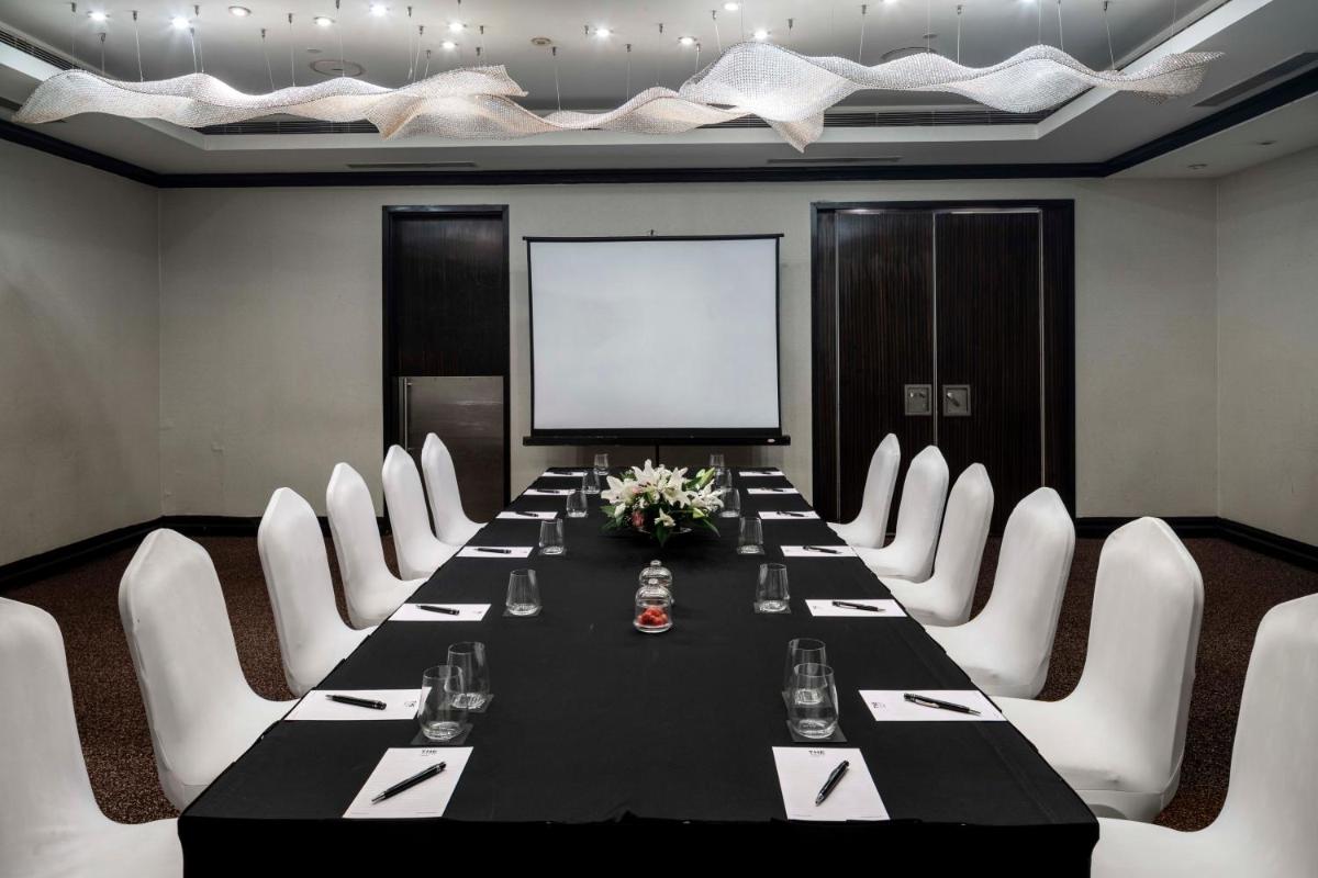 a conference room with a long table and white chairs at The Park Chennai in Chennai