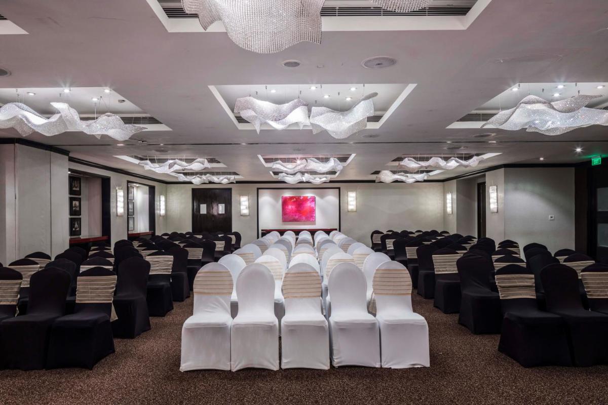 a conference room with white chairs and a projection screen at The Park Chennai in Chennai