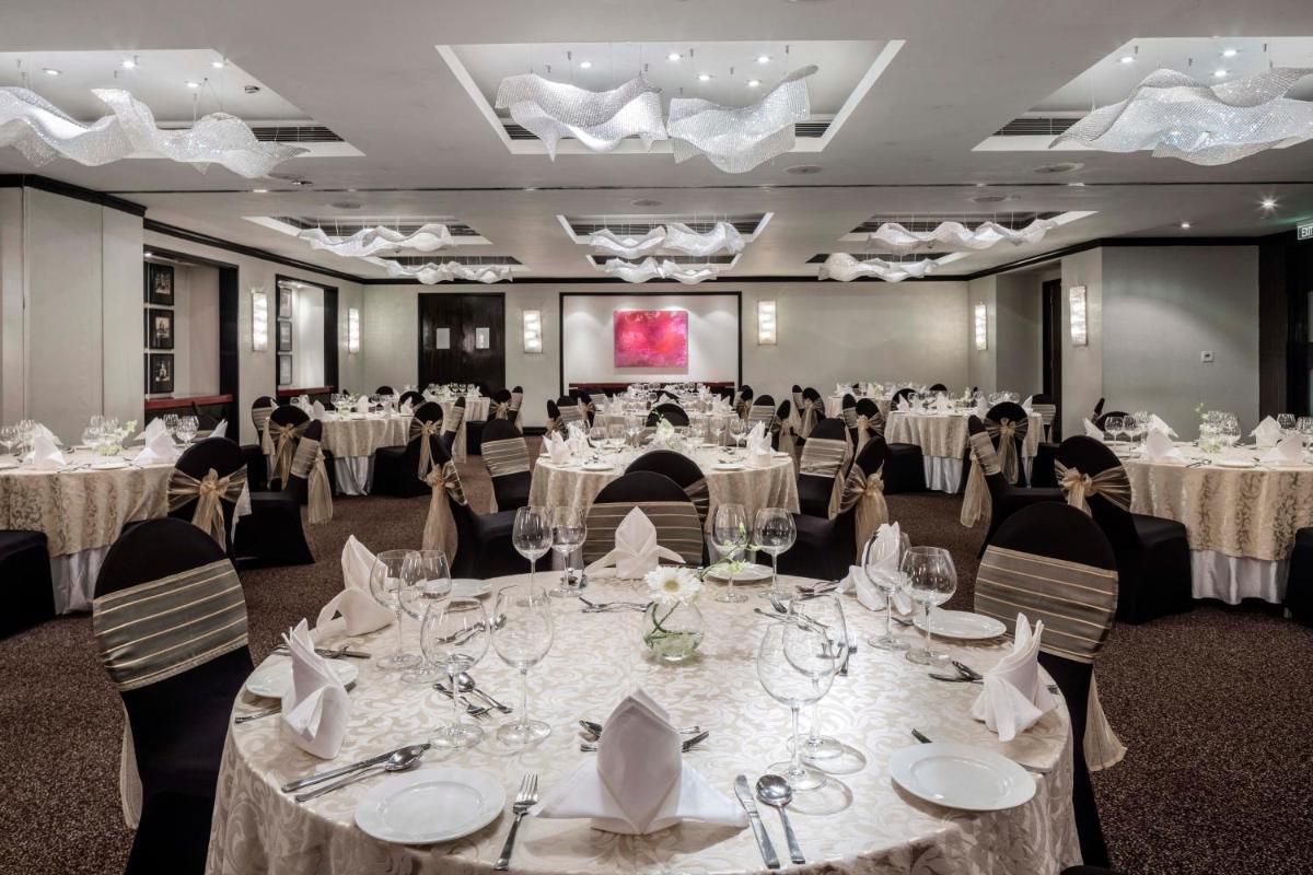 a banquet room with tables with white tablecloths at The Park Chennai in Chennai +80 photos
