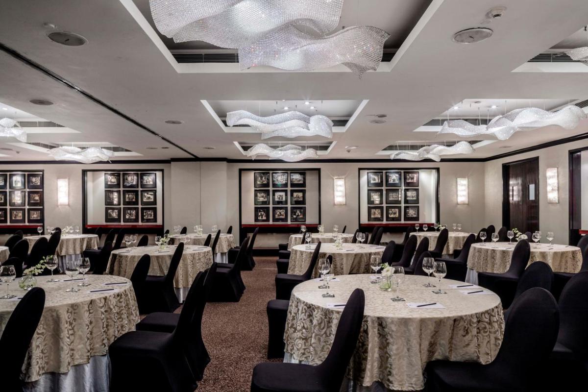 a banquet room with white tables and black chairs at The Park Chennai in Chennai