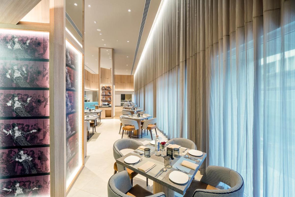 a restaurant with tables and chairs in a room at The Park Chennai in Chennai