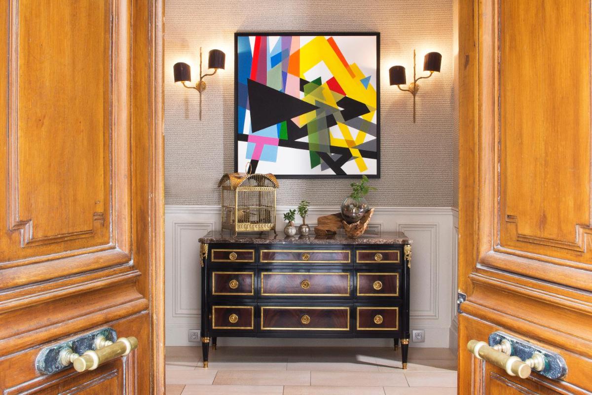 une commode dans un couloir avec un tableau sur le mur dans l'établissement Hotel Monge, à Paris