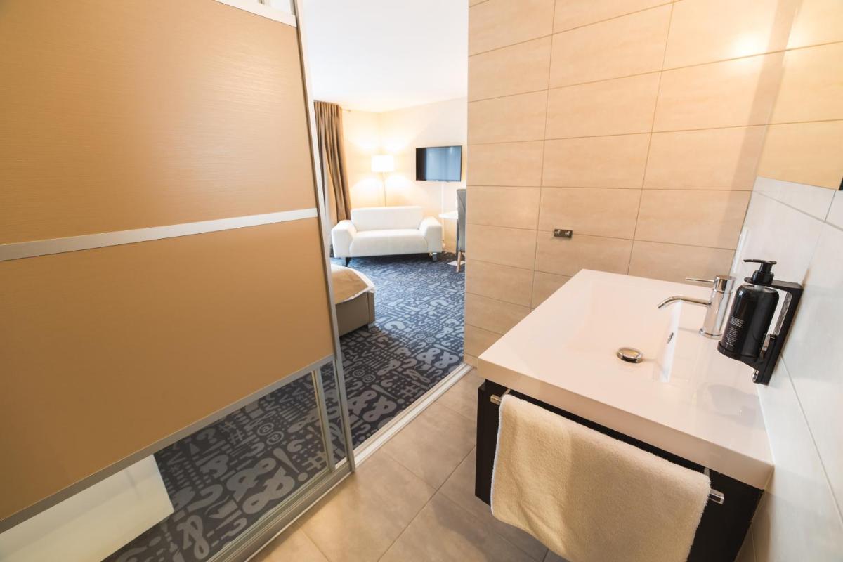 Un ou plusieurs lits dans un hébergement de l'établissement Hôtel Le Dormeur