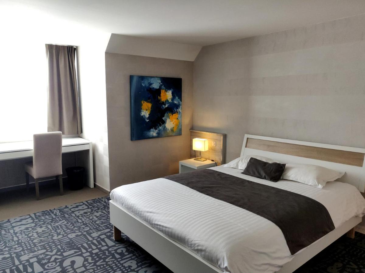 une chambre avec un grand lit et un tableau au mur dans l'établissement Hôtel Le Dormeur, à Dorlisheim
