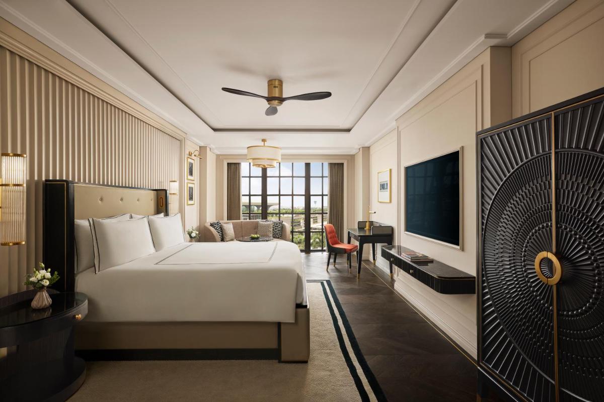 a hotel room with a bed and a television at Fairmont Mumbai in Mumbai