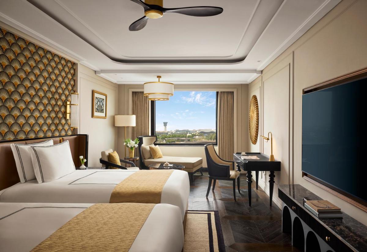 a hotel room with a bed and a flat screen tv at Fairmont Mumbai in Mumbai