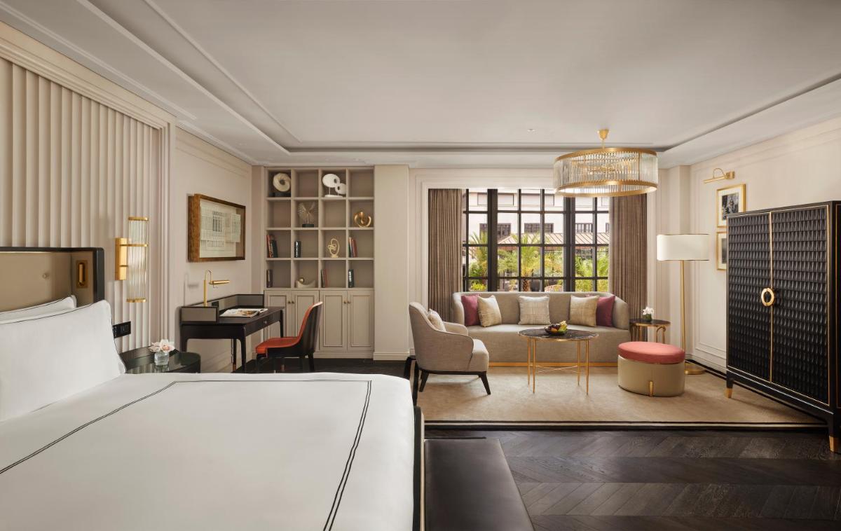 a bedroom with a bed and a living room at Fairmont Mumbai in Mumbai