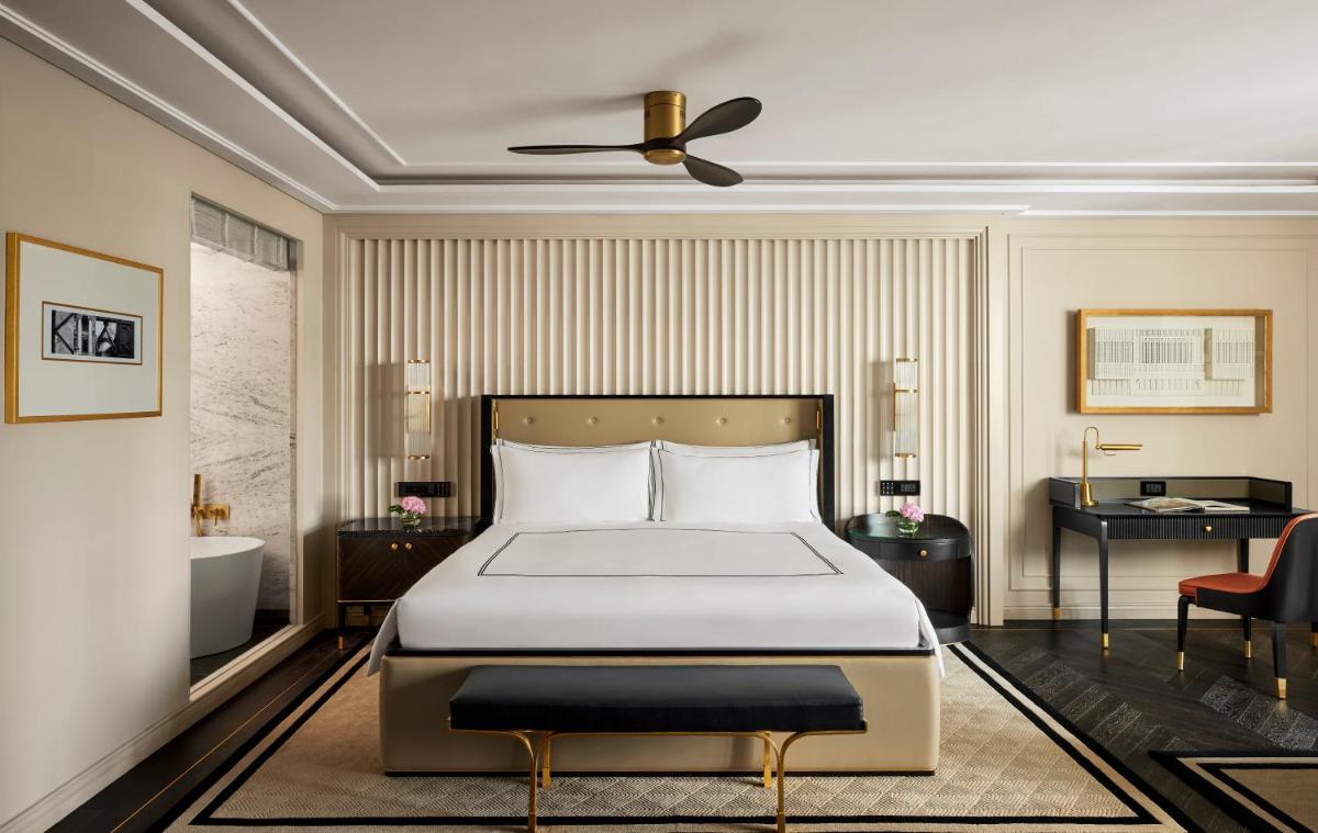 a bedroom with a bed and a bathroom at Fairmont Mumbai in Mumbai