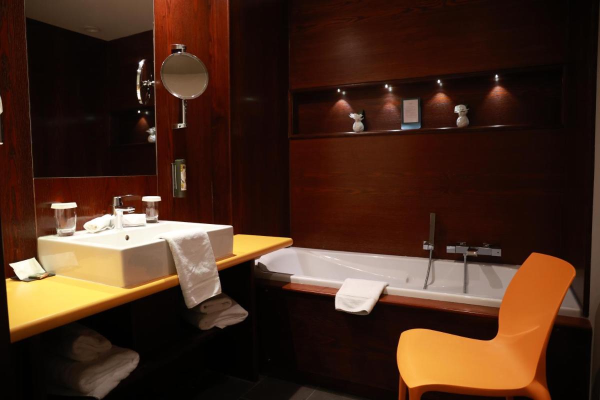 une salle de bains avec lavabo et baignoire dans l'établissement Hotel - Restaurant Le Cerf & Spa, à Marlenheim
