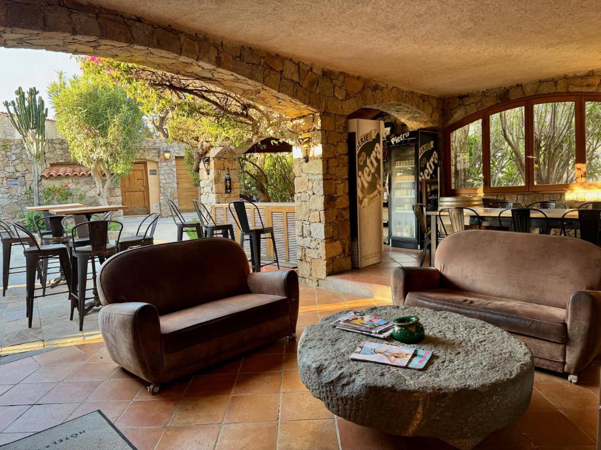 un salon avec deux chaises et une table dans l'établissement Hôtel Casa Rossa & Spa, à LʼÎle-Rousse