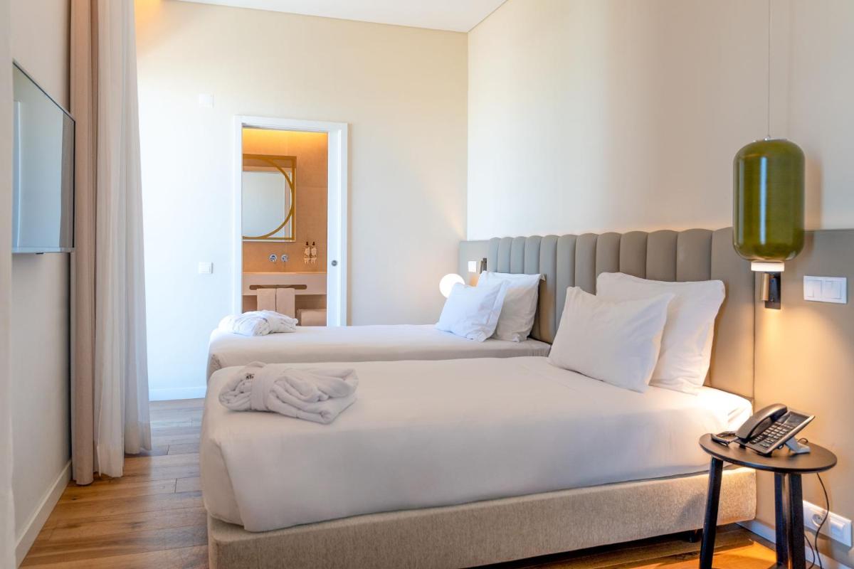 Uma cama ou camas num quarto em Sines Sea View Business & Leisure Hotel