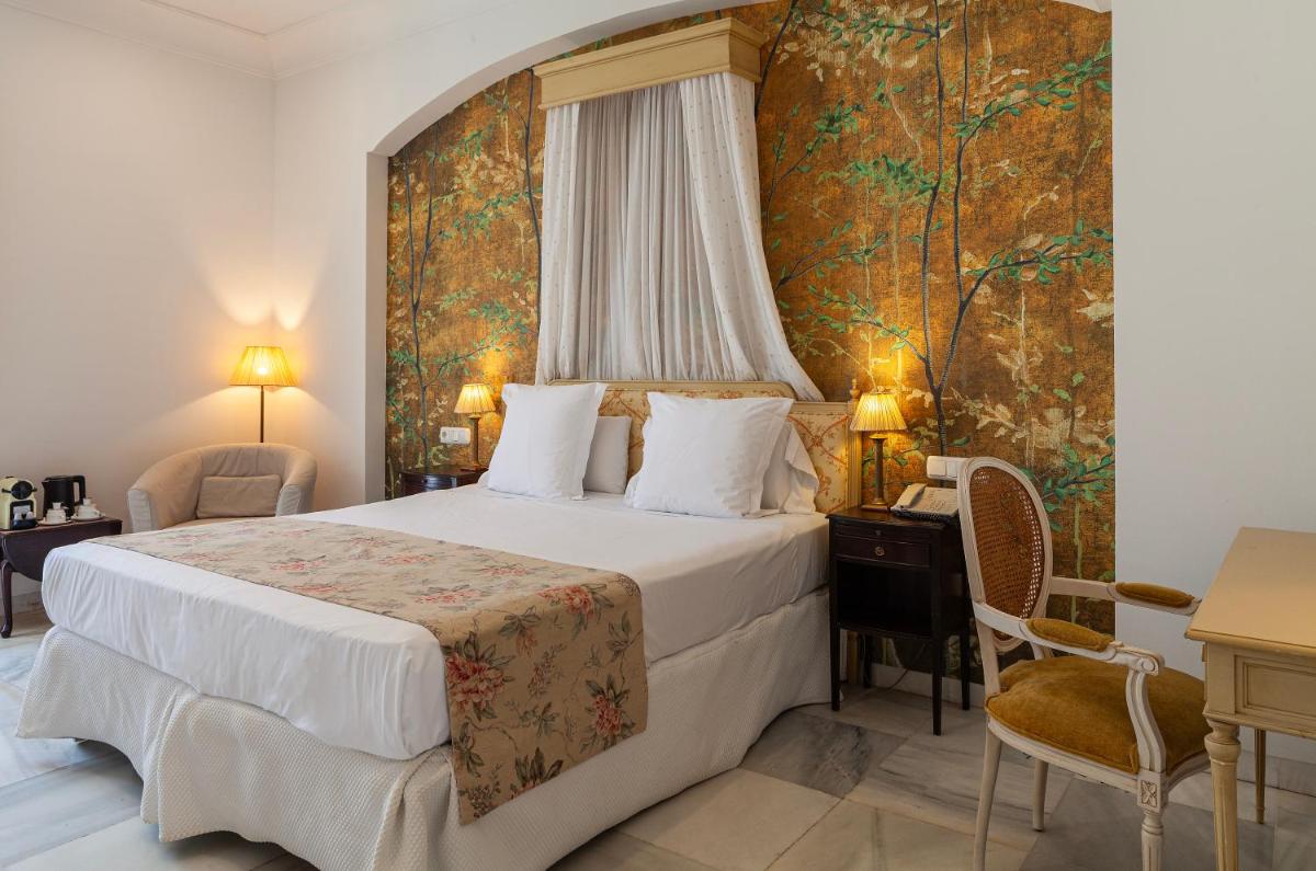 Una habitación de hotel con una cama y un mural en la pared. en Villa Jerez, en Jerez de la Frontera Una habitación de hotel con una cama y un mural en la pared. en Villa Jerez, en Jerez de la Frontera