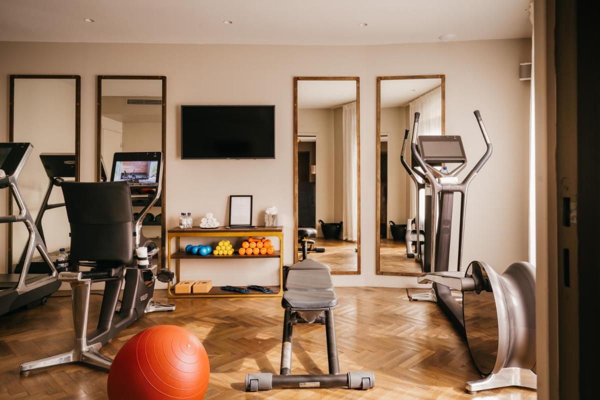 une salle de sport avec plusieurs appareils de musculation dans une pièce dans l'établissement Hôtel Les Roches Blanches Cassis, à Cassis