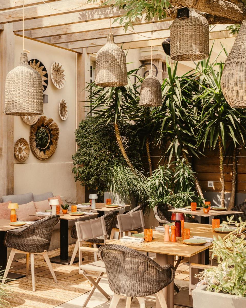 un restaurant avec des tables, des chaises et des plantes en pot dans l'établissement Hôtel Les Roches Blanches Cassis, à Cassis