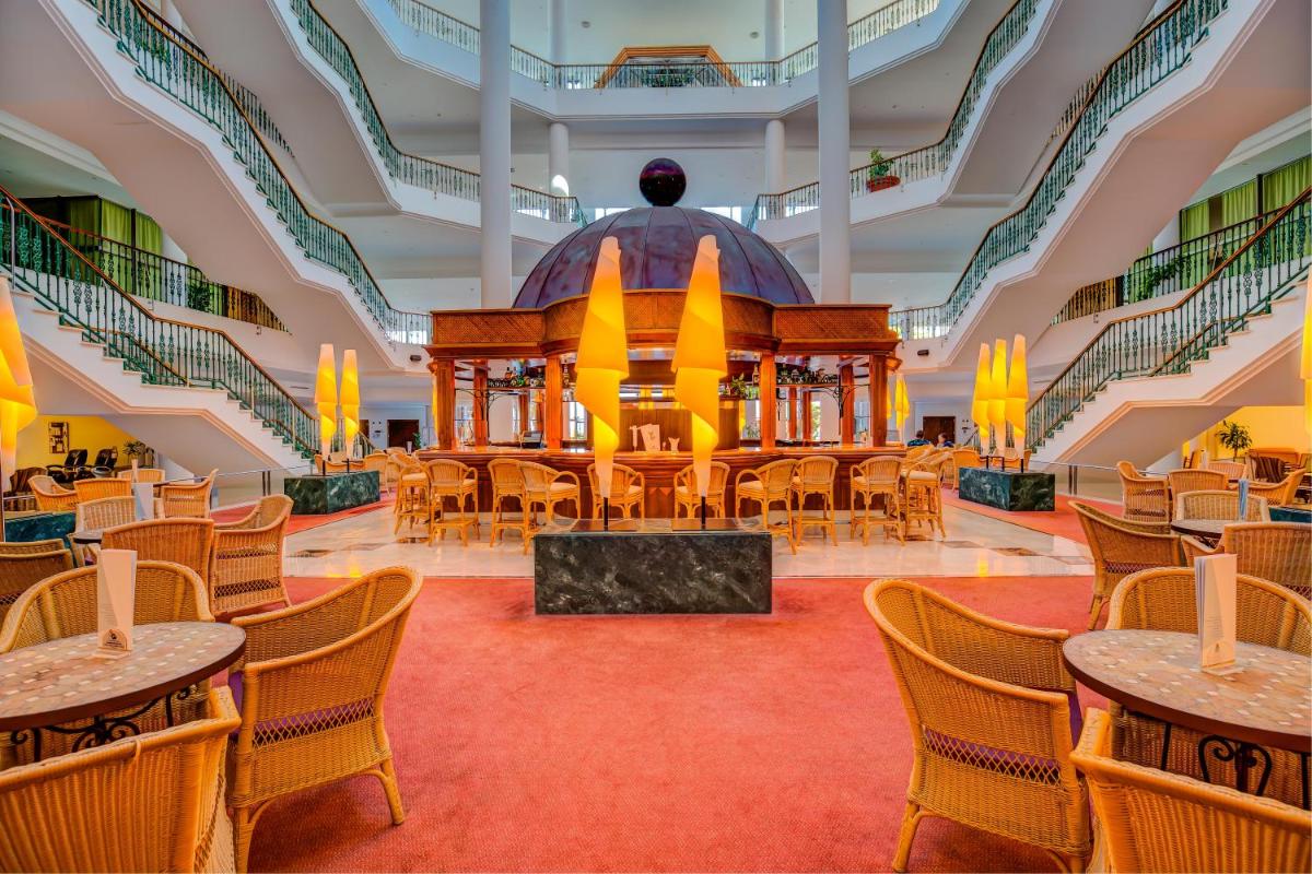 Habitación grande con mesas, sillas y escaleras. en SBH Costa Calma Palace Thalasso & Spa, en Costa Calma