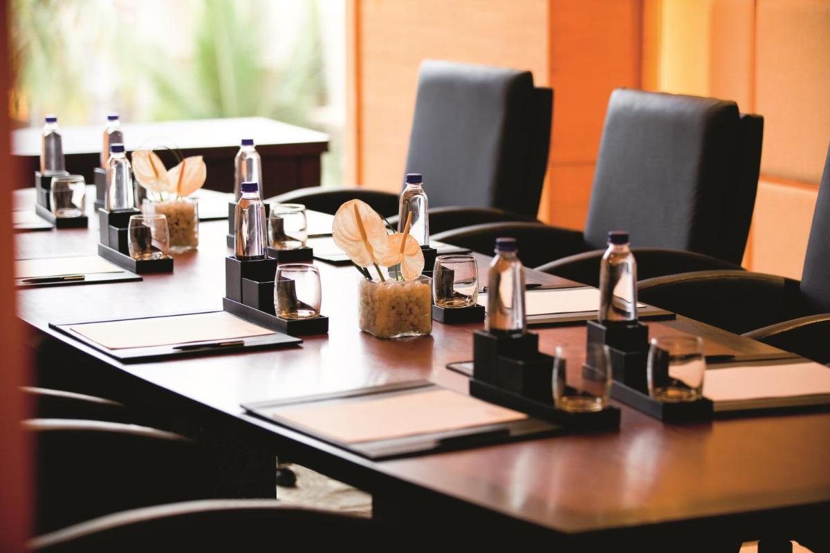 a long table with bottles on it with chairs at Gokulam Grand Hotel & Spa Bangalore in Bengaluru a long table with bottles on it with chairs at Gokulam Grand Hotel & Spa Bangalore in Bengaluru