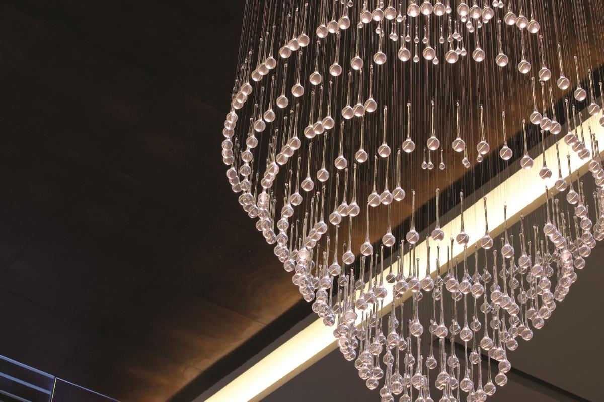 a chandelier with crystals hanging from a ceiling at Gokulam Grand Hotel & Spa Bangalore in Bengaluru a chandelier with crystals hanging from a ceiling at Gokulam Grand Hotel & Spa Bangalore in Bengaluru