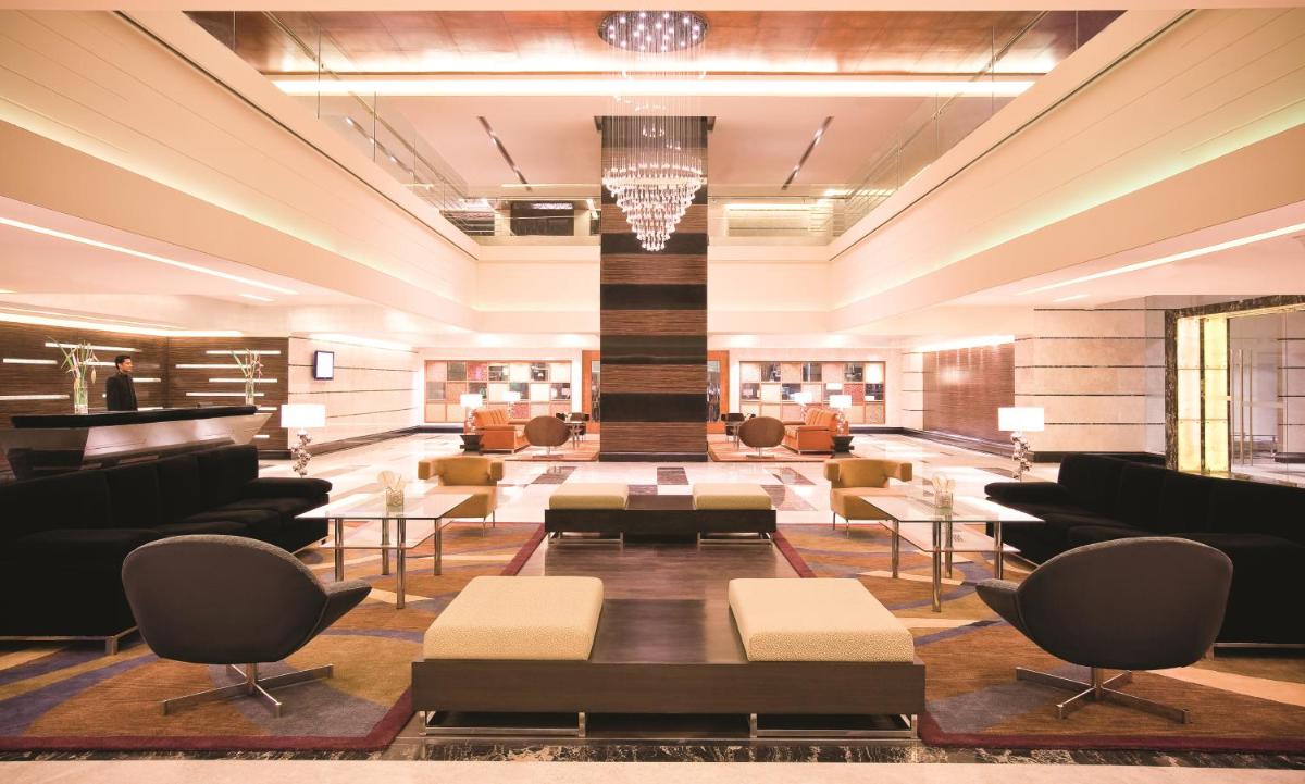 a lobby with couches and tables and a piano at Gokulam Grand Hotel & Spa Bangalore in Bengaluru a lobby with couches and tables and a piano at Gokulam Grand Hotel & Spa Bangalore in Bengaluru