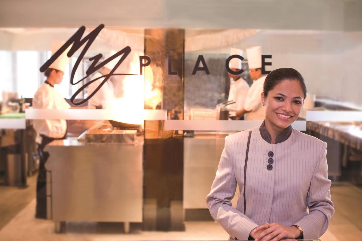 a woman is standing in front of a restaurant at Gokulam Grand Hotel & Spa Bangalore in Bengaluru a woman is standing in front of a restaurant at Gokulam Grand Hotel & Spa Bangalore in Bengaluru