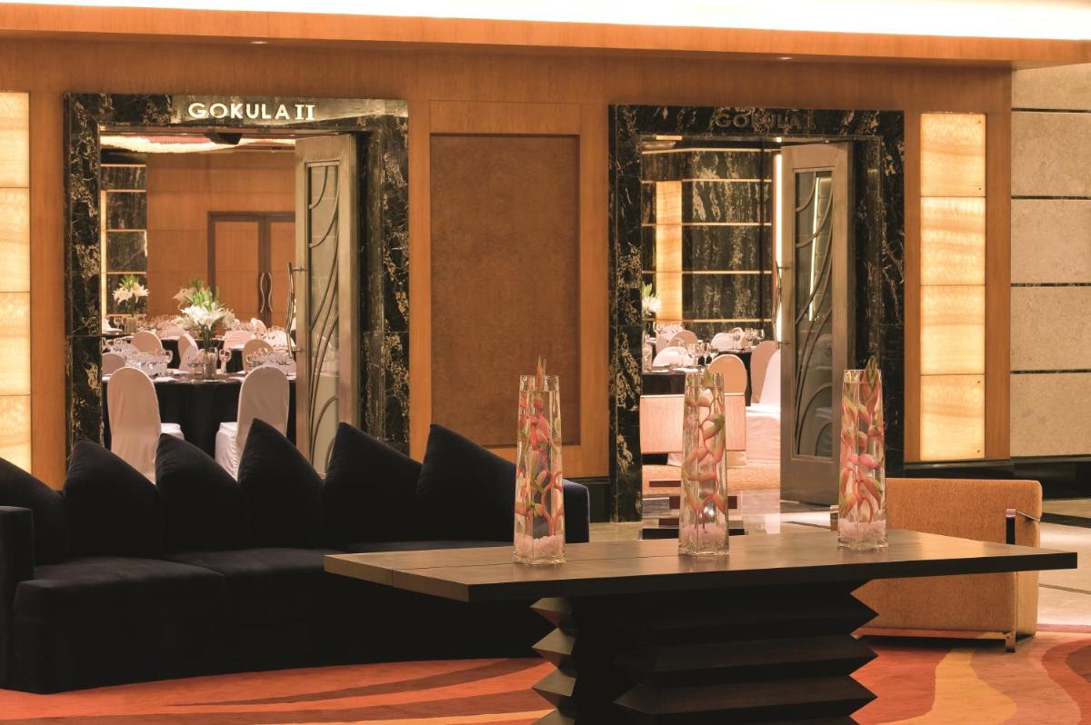 a dining room with a table and chairs and a table sidx sidx sidx at Gokulam Grand Hotel & Spa Bangalore in Bengaluru a dining room with a table and chairs and a table sidx sidx sidx at Gokulam Grand Hotel & Spa Bangalore in Bengaluru