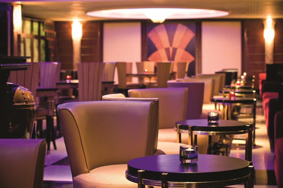 a dining room with tables and chairs and tablesktop at Gokulam Grand Hotel & Spa Bangalore in Bengaluru a dining room with tables and chairs and tablesktop at Gokulam Grand Hotel & Spa Bangalore in Bengaluru