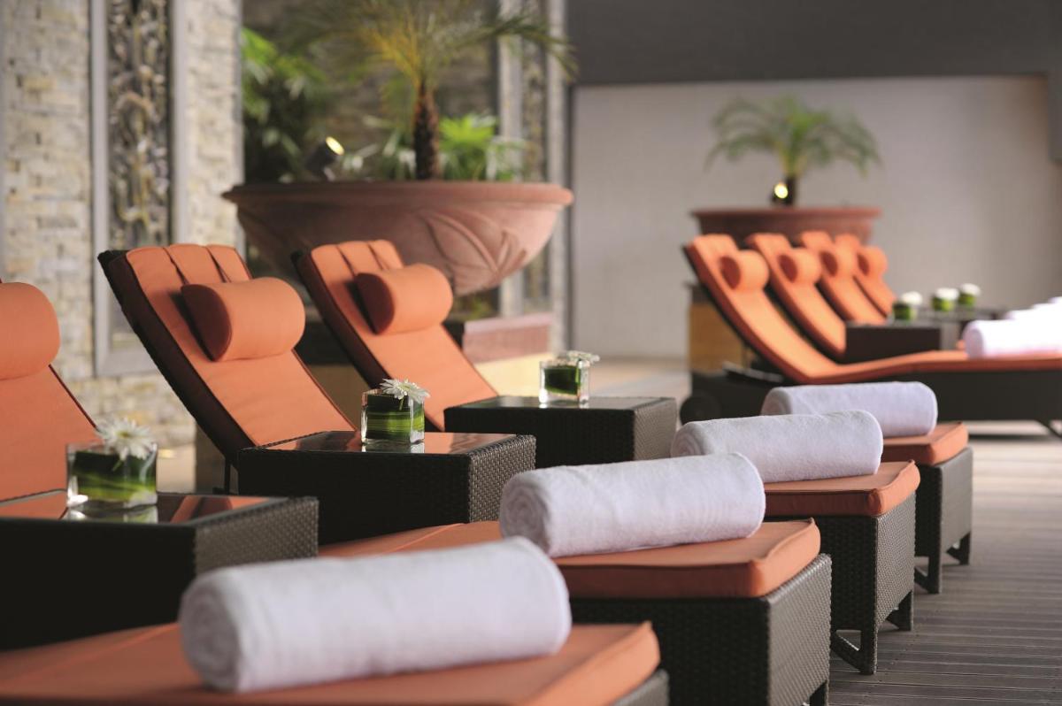 a row of chairs and tables in a restaurant at Gokulam Grand Hotel & Spa Bangalore in Bengaluru a row of chairs and tables in a restaurant at Gokulam Grand Hotel & Spa Bangalore in Bengaluru