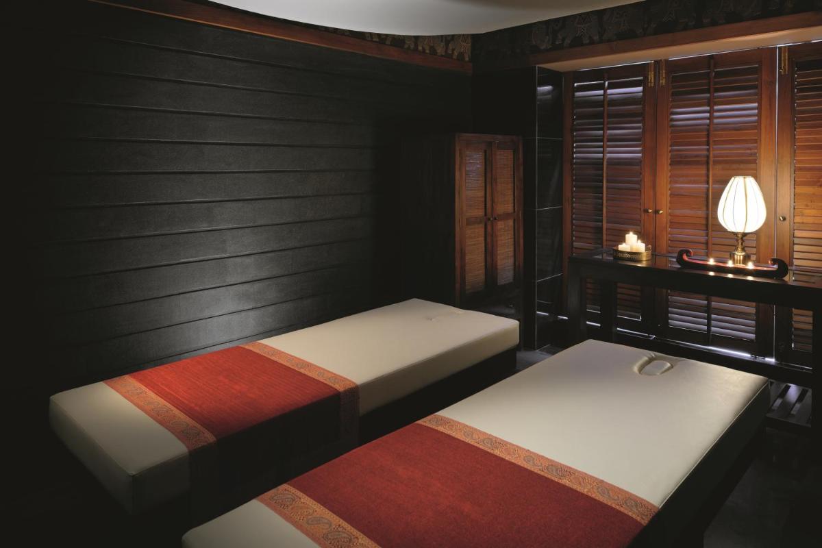 a bedroom with two beds and a lamp and a window at Gokulam Grand Hotel & Spa Bangalore in Bengaluru a bedroom with two beds and a lamp and a window at Gokulam Grand Hotel & Spa Bangalore in Bengaluru