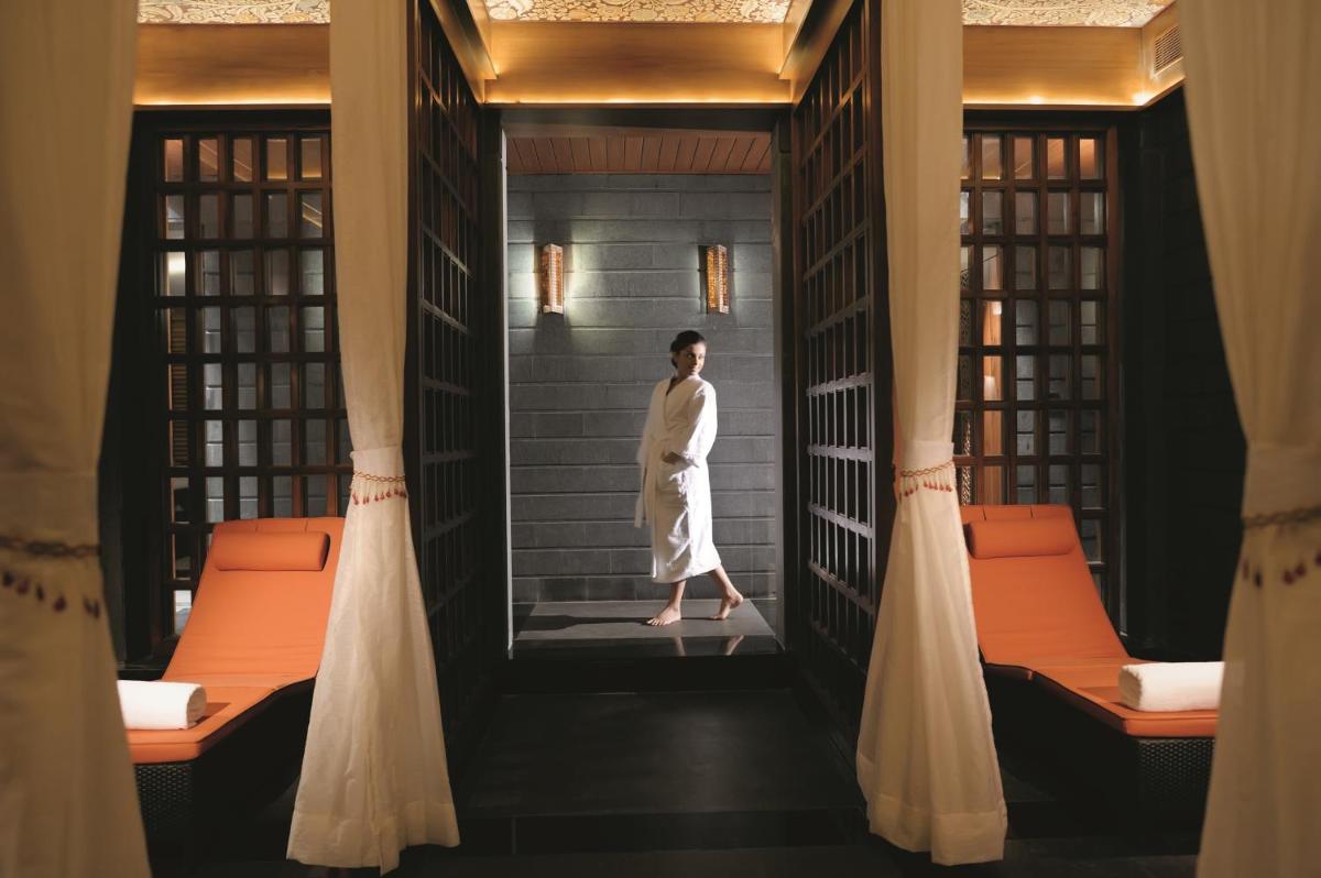 a woman standing in a corridor in a room at Gokulam Grand Hotel & Spa Bangalore in Bengaluru a woman standing in a corridor in a room at Gokulam Grand Hotel & Spa Bangalore in Bengaluru
