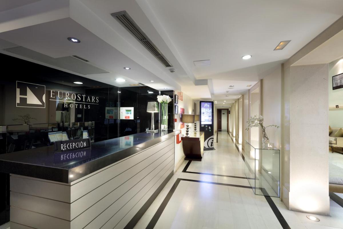 Un vestíbulo de una tienda con un mostrador y un bar. en Eurostars Gran Via, en Granada