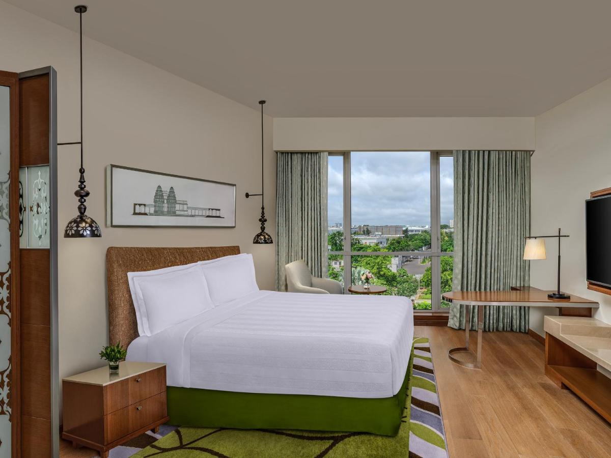 a hotel room with a bed and a large window at ITC Kakatiya, a Luxury Collection Hotel, Hyderabad in Hyderabad