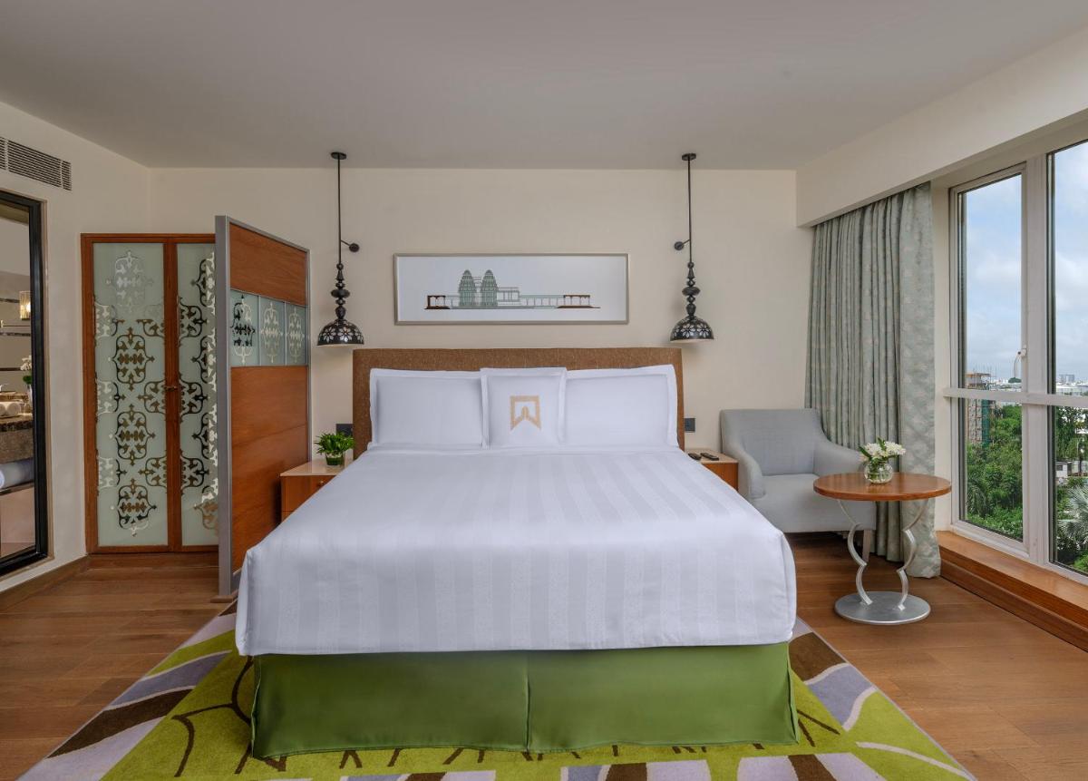 a bedroom with a large white bed and windows at ITC Kakatiya, a Luxury Collection Hotel, Hyderabad in Hyderabad