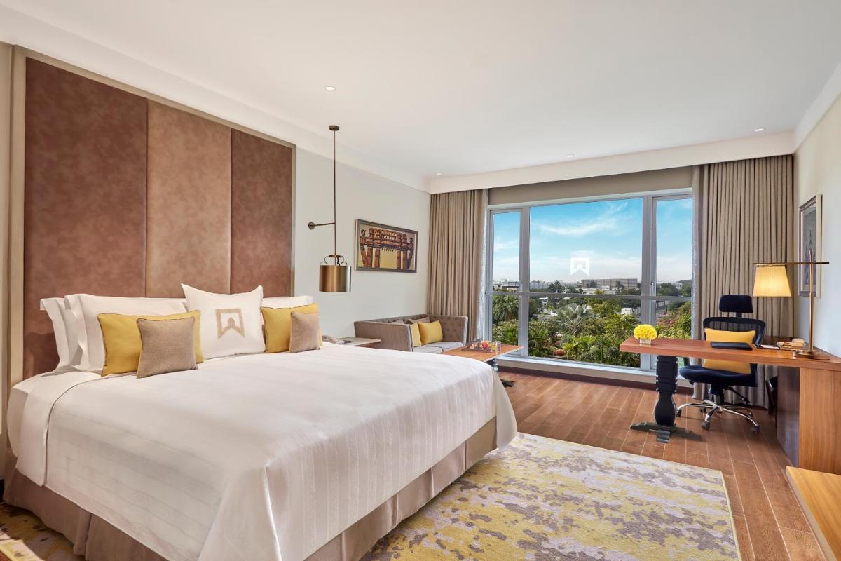 a hotel room with a large bed and a desk at ITC Kakatiya, a Luxury Collection Hotel, Hyderabad in Hyderabad