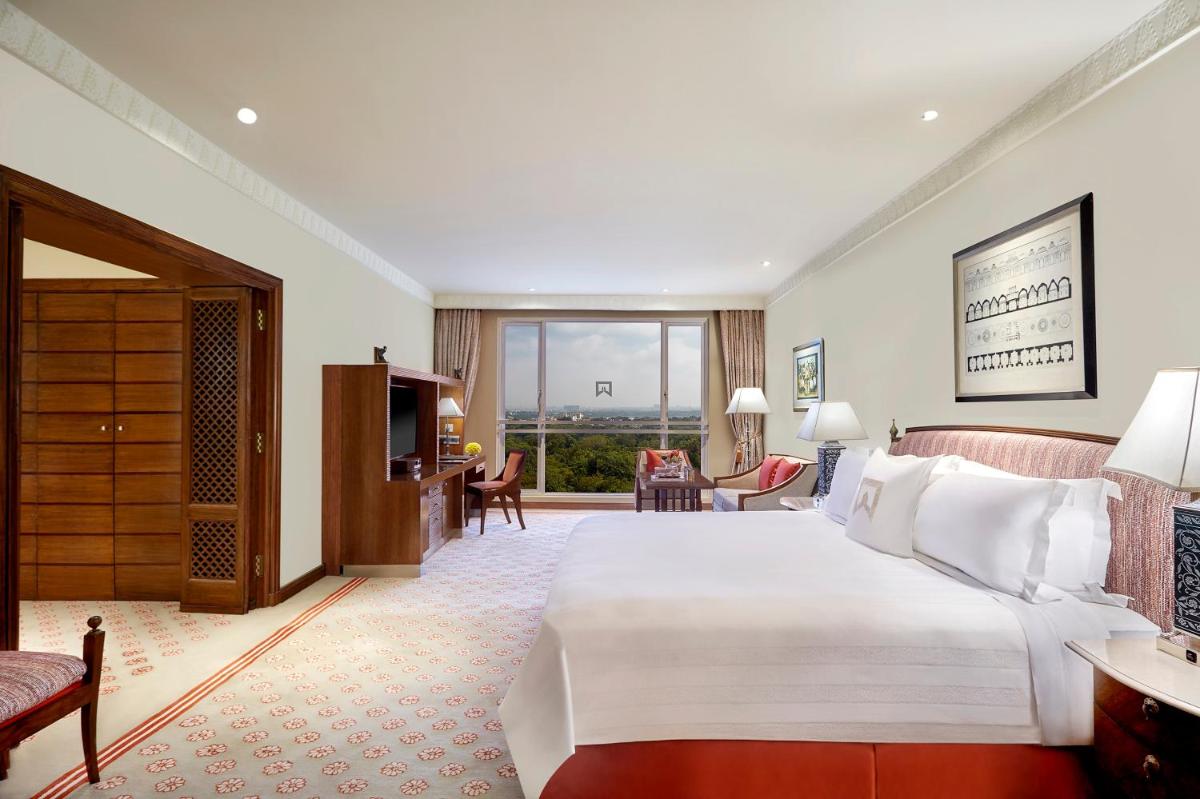 a bedroom with a large bed and a living room at ITC Kakatiya, a Luxury Collection Hotel, Hyderabad in Hyderabad