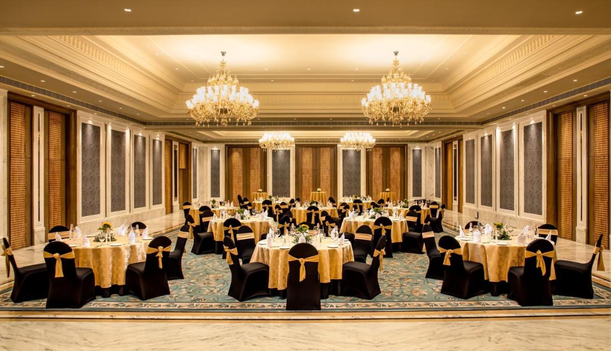 a ballroom with tables and chairs and chandeliers at ITC Kakatiya, a Luxury Collection Hotel, Hyderabad in Hyderabad