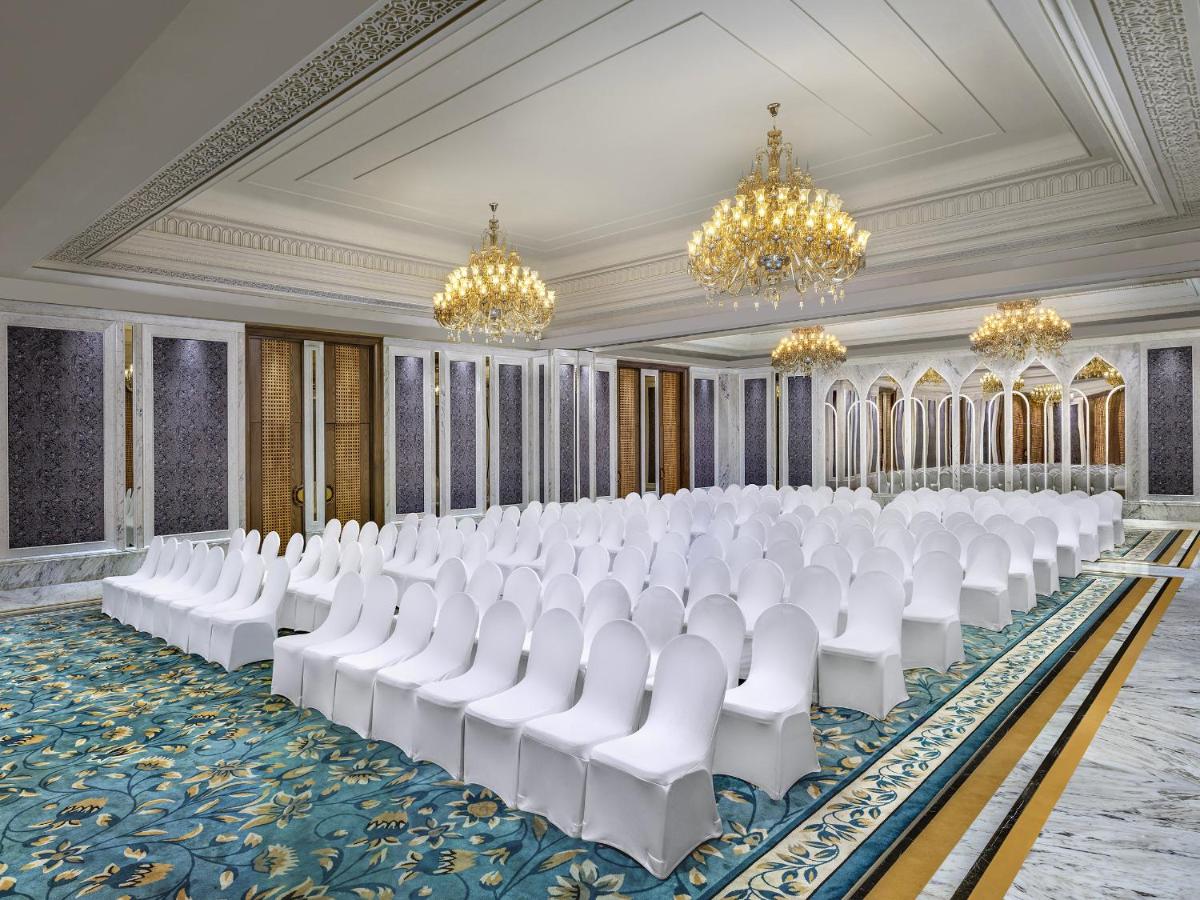 a ballroom with white chairs and chandeliers at ITC Kakatiya, a Luxury Collection Hotel, Hyderabad in Hyderabad