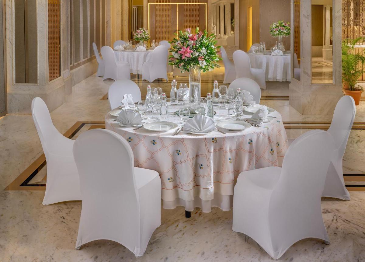 a dining room with a table and white chairs at ITC Kakatiya, a Luxury Collection Hotel, Hyderabad in Hyderabad