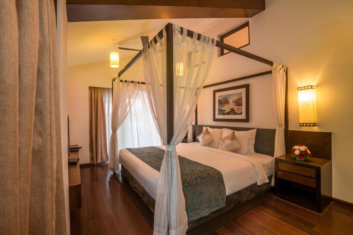 a bedroom with a bed with a canopy at Deltin Suites in Candolim