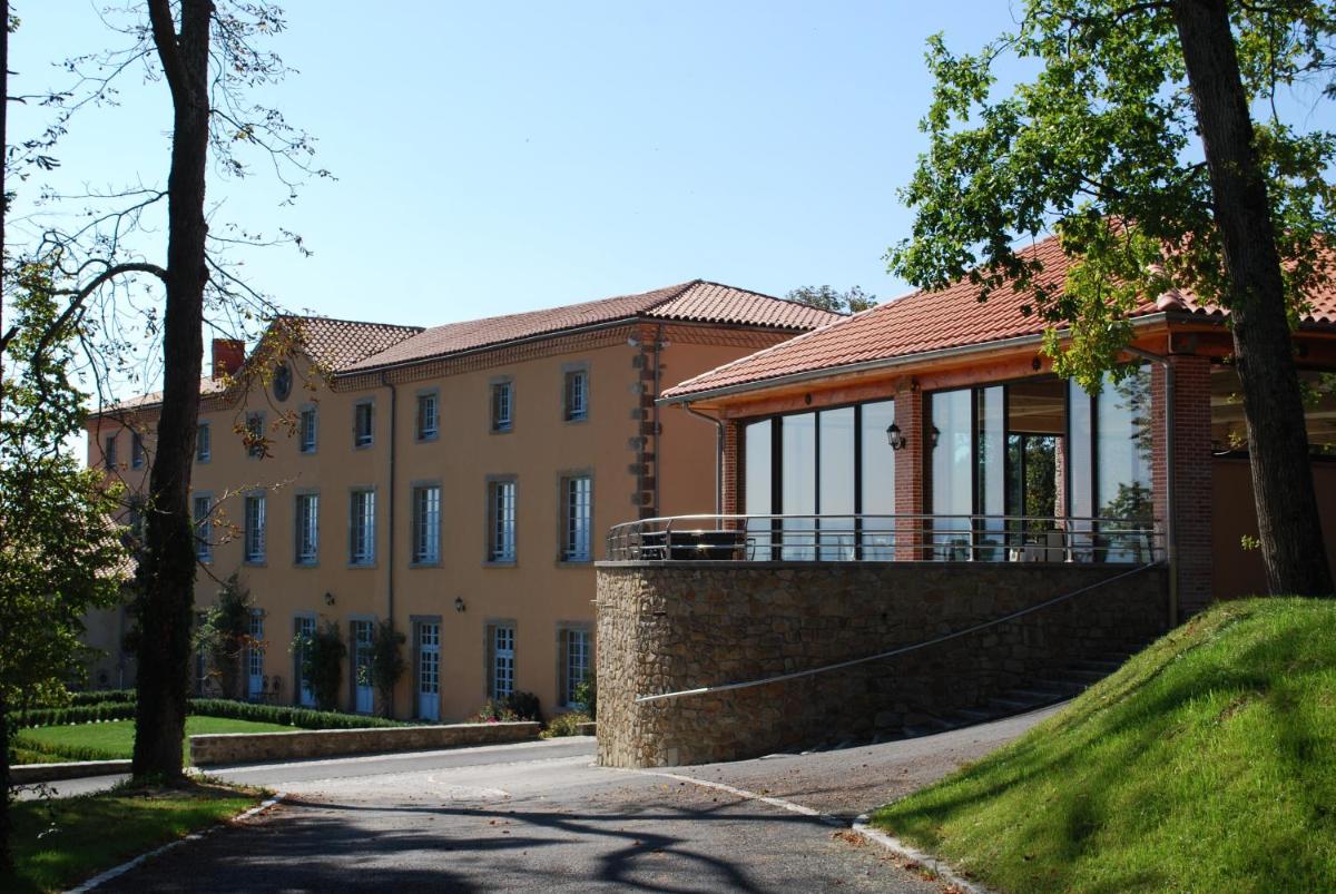 - un grand bâtiment avec une terrasse couverte sur le côté dans l'établissement Domaine Saint-Roch Hotel Spa, à Salzuit