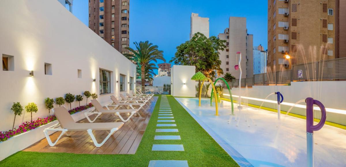 Una piscina en la azotea de un edificio con tumbonas. en RH Princesa Hotel & Spa 4* Sup, en Benidorm