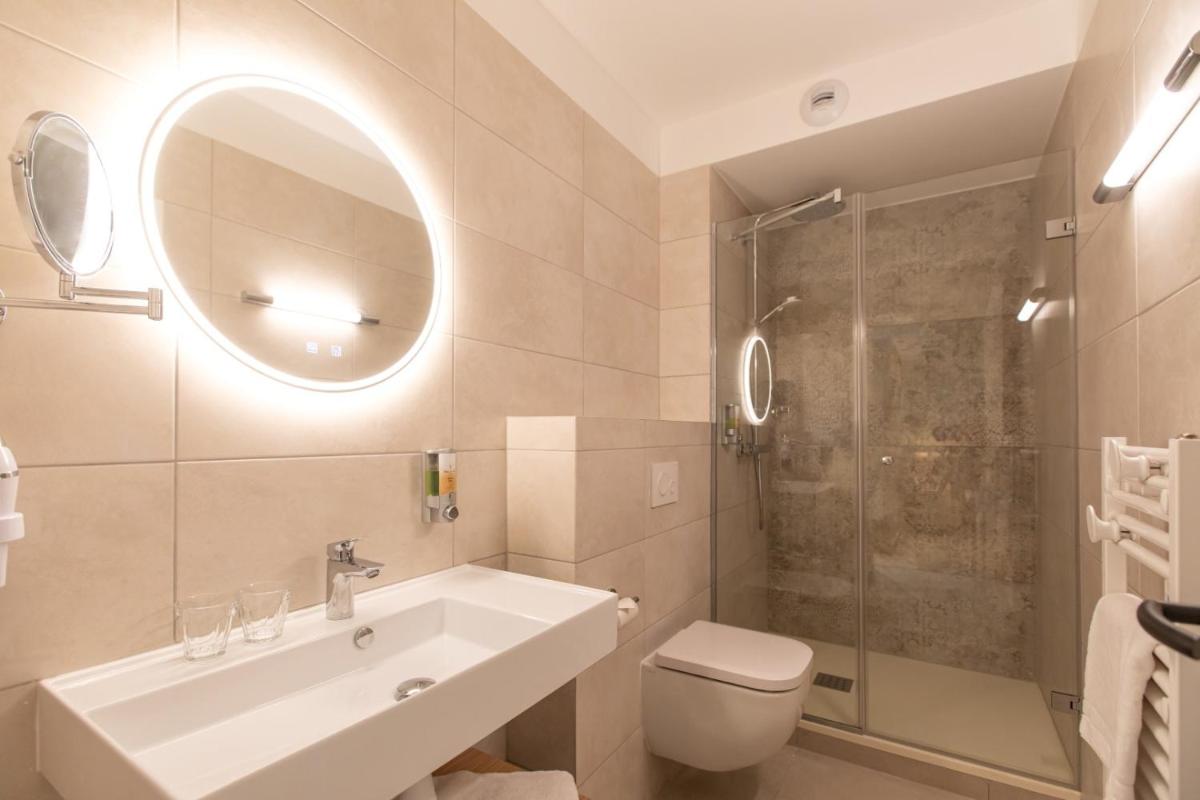 une salle de bains avec lavabo, toilettes et douche dans l'établissement Hôtel Terra Vinum, à Gueberschwihr